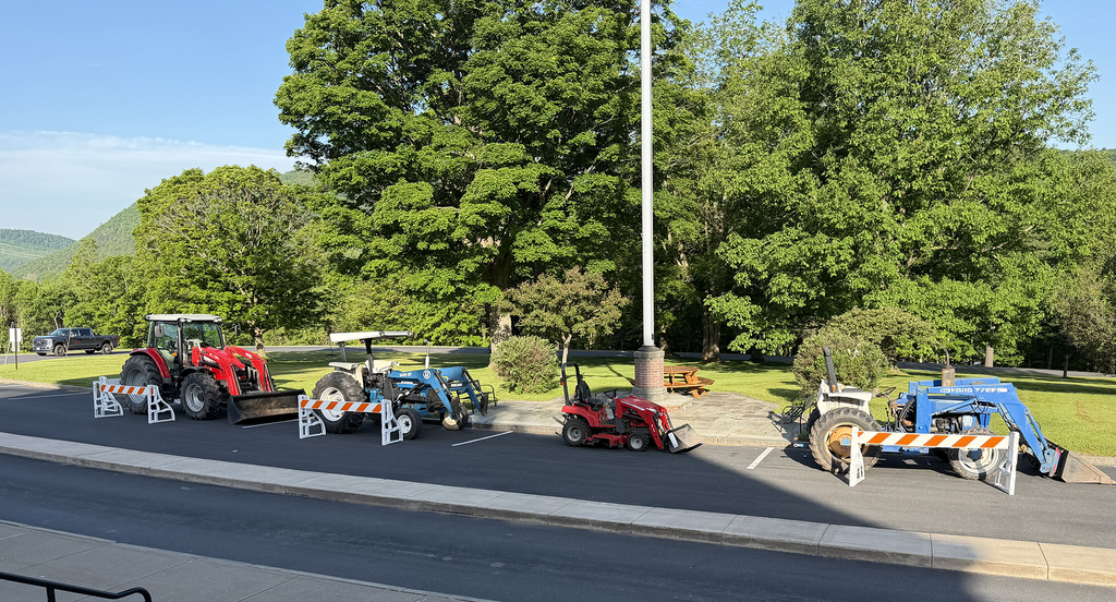 Four tractors parked in front of flagpole