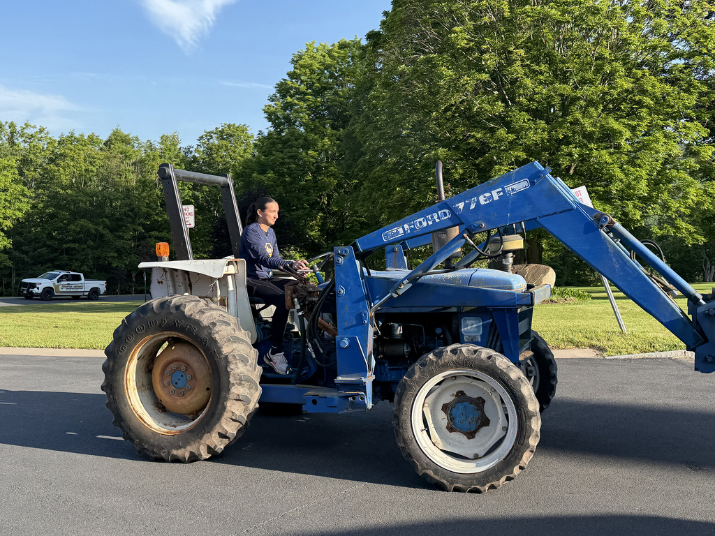student on blue tractor