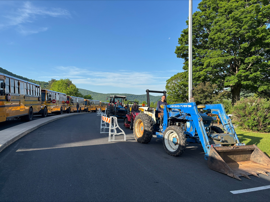 tractors parked in front of school buses