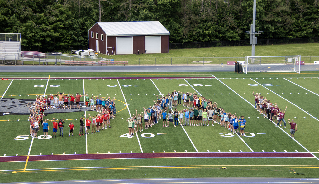 students and staff spell DA on the football field