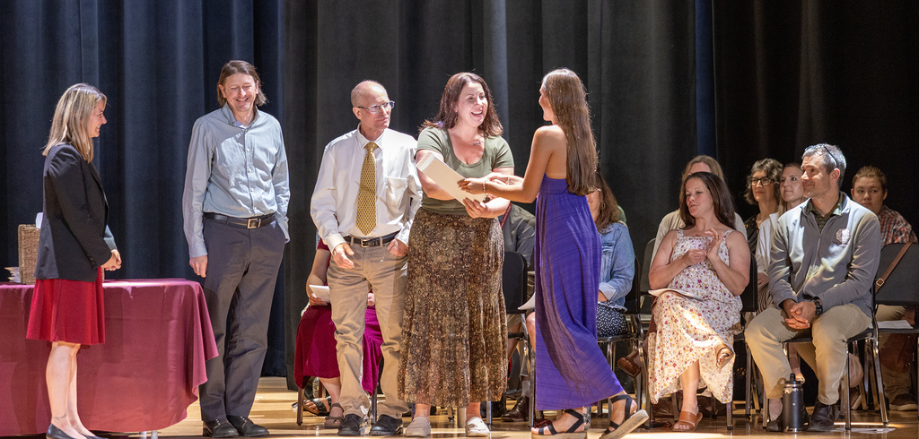 Ms. Trask and two teachers watch as teacher shakes student's hand