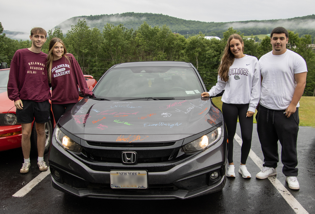 4 seniors pose with their car