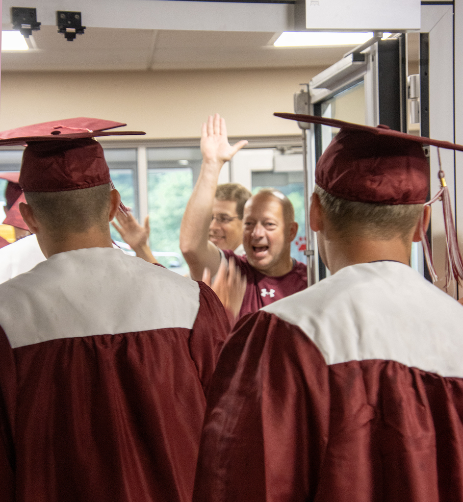 Mr. Ferrara gives a big high five to a senior