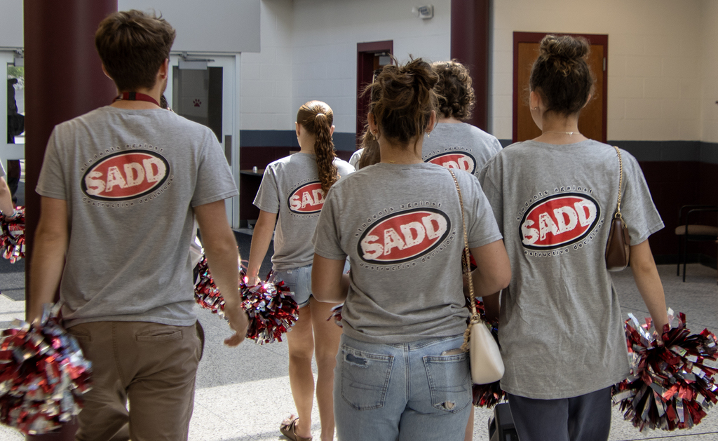 SADD advisor and members in hallway of middle school; SADD logo on back of their shirts