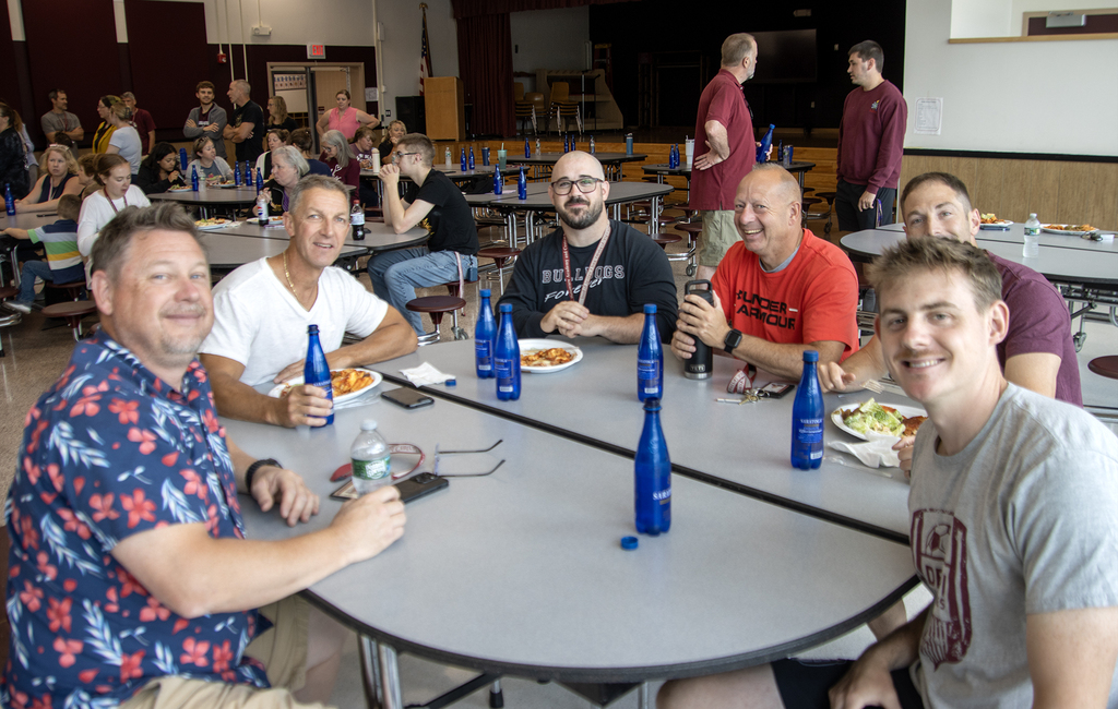 6 male teachers smiling at table