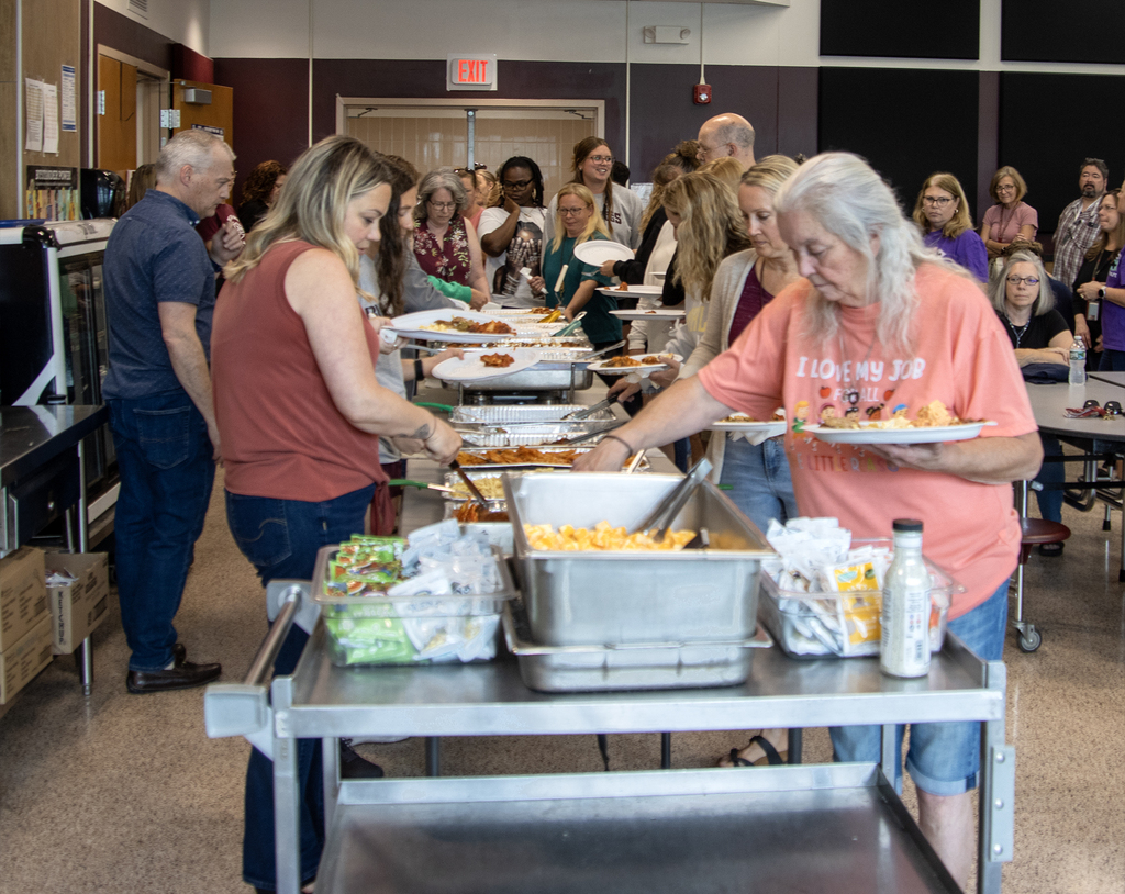 staff fill plates from a buffet line