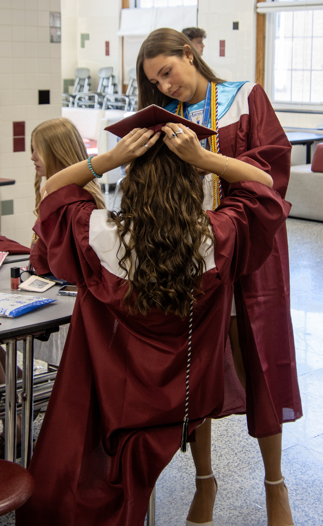 senior helping another senior with her cap