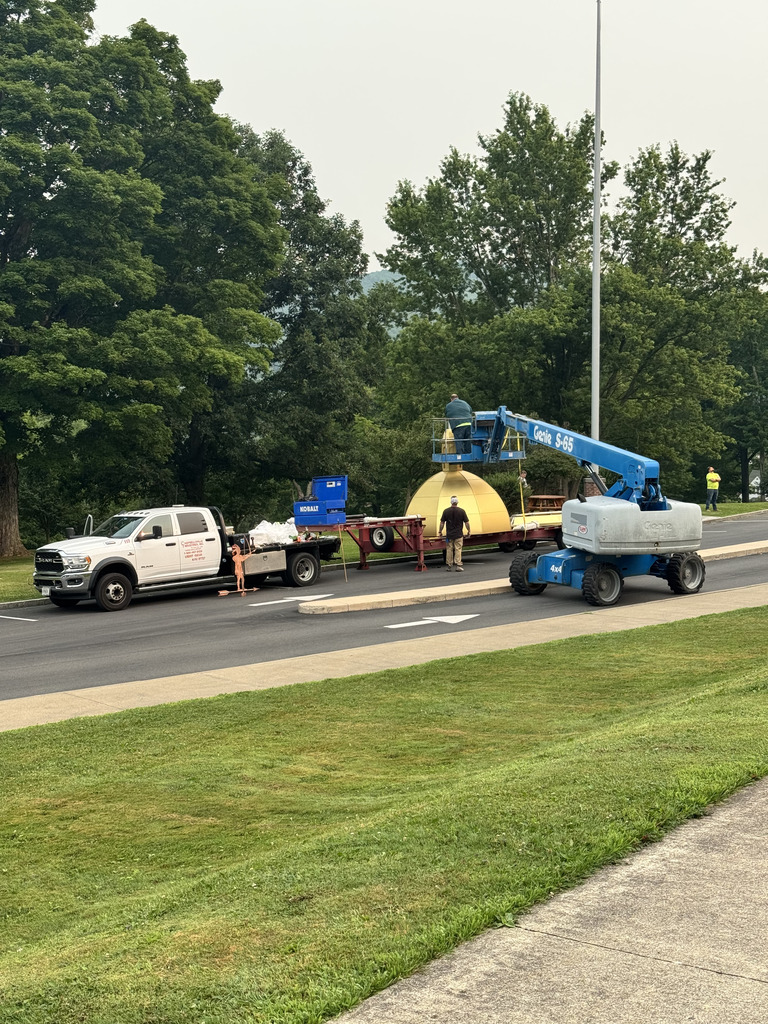 worker in lift works on dome on trailer