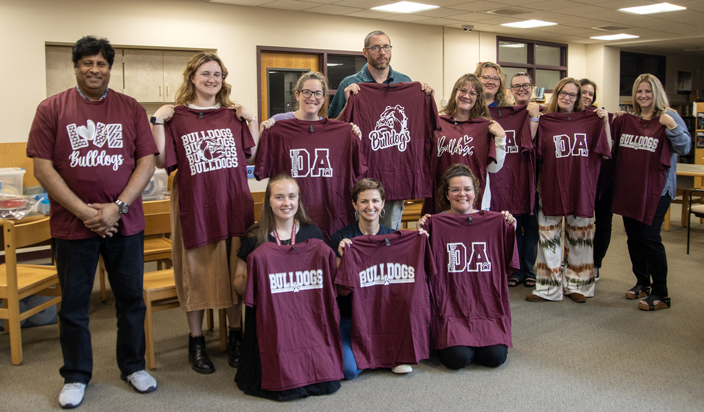 New hires pose with their new DA Bulldog shirts