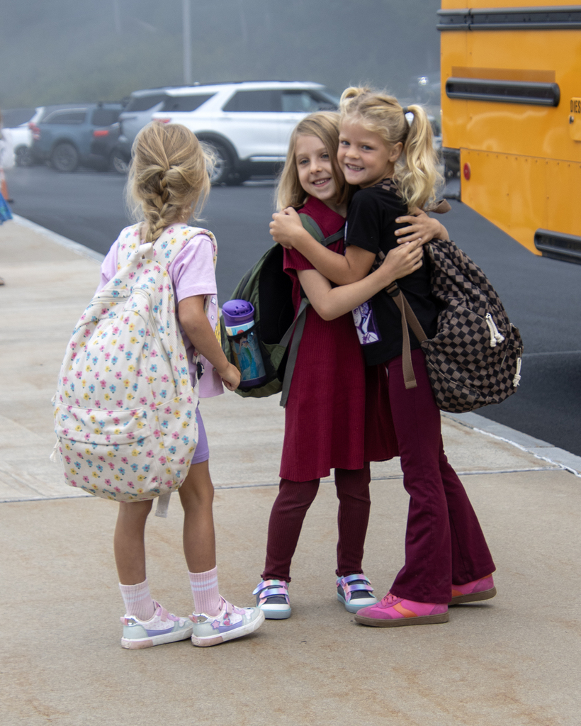 3 elementary students hugging