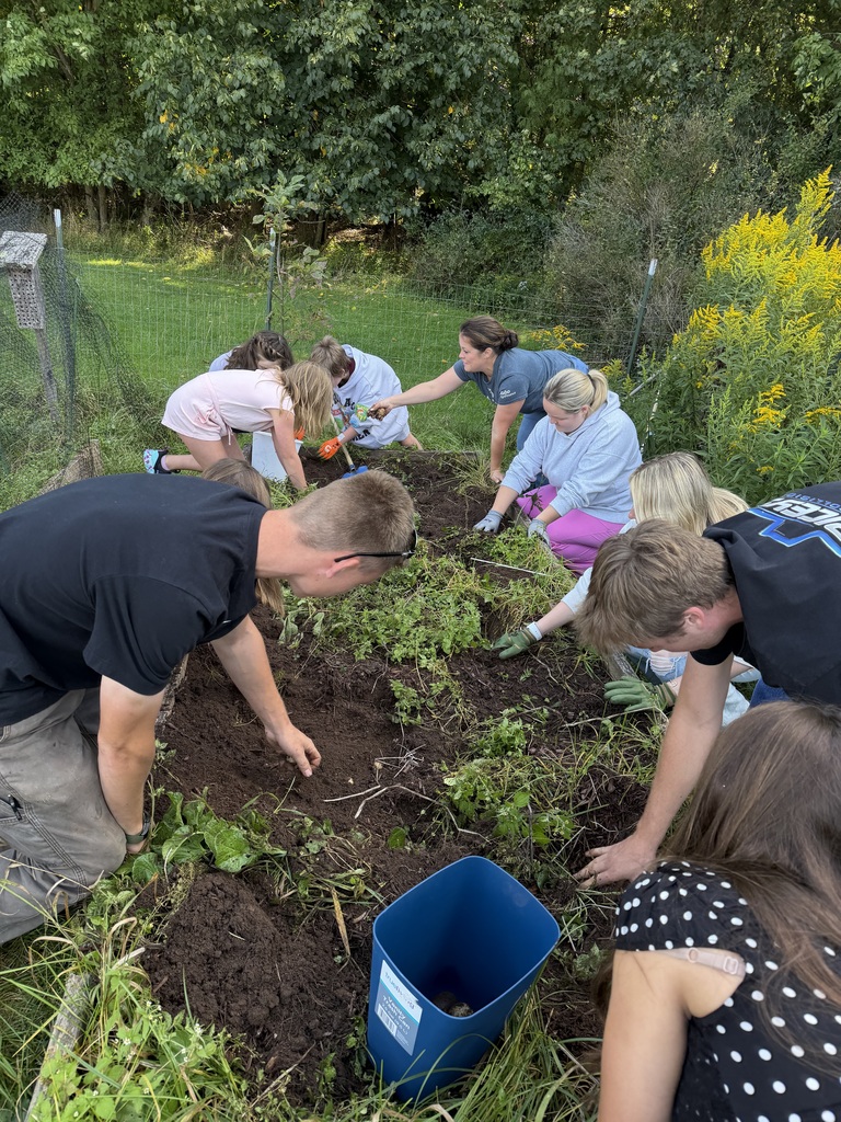 10 students digging in the school garden