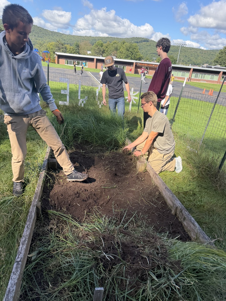 4 students working in the school garden bed