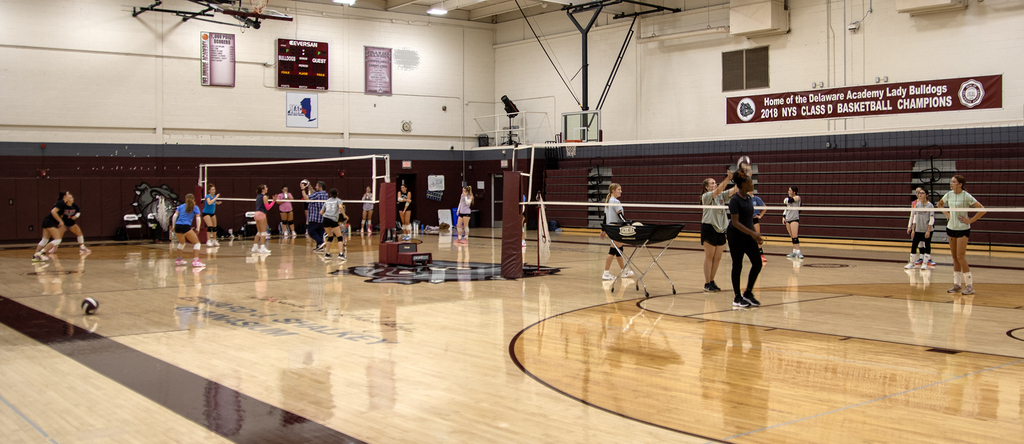 varsity volleyball team practicing in gym