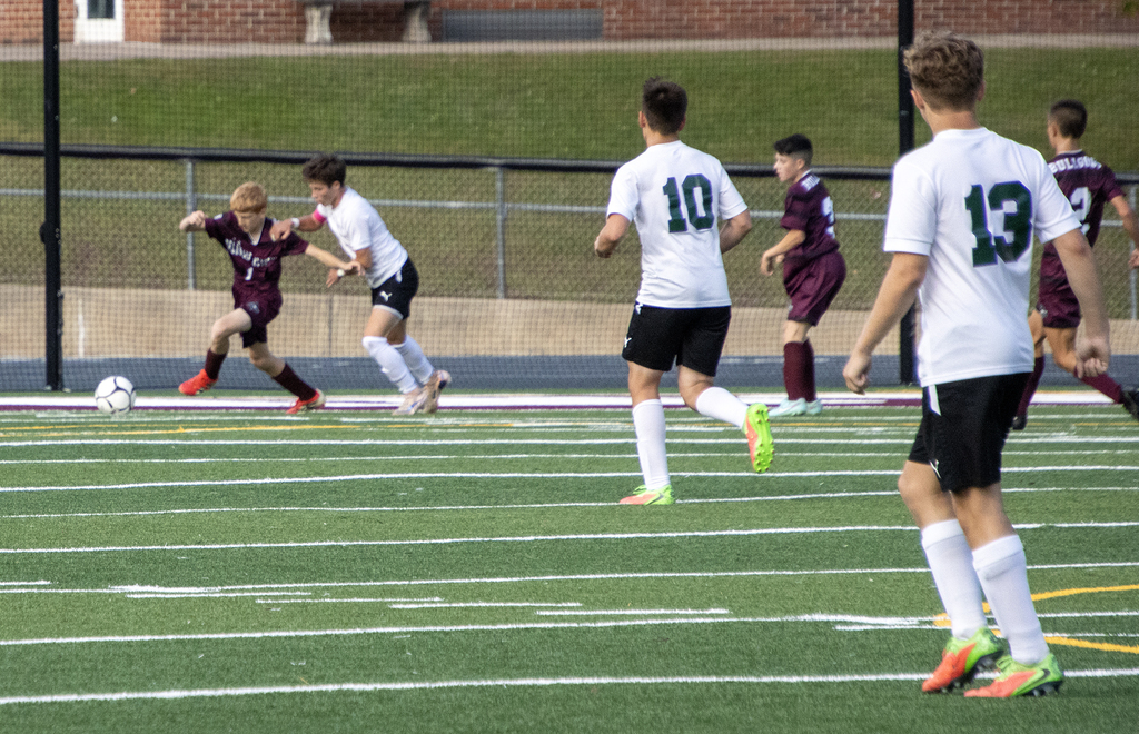 one player with the soccer ball surrounded by defenders