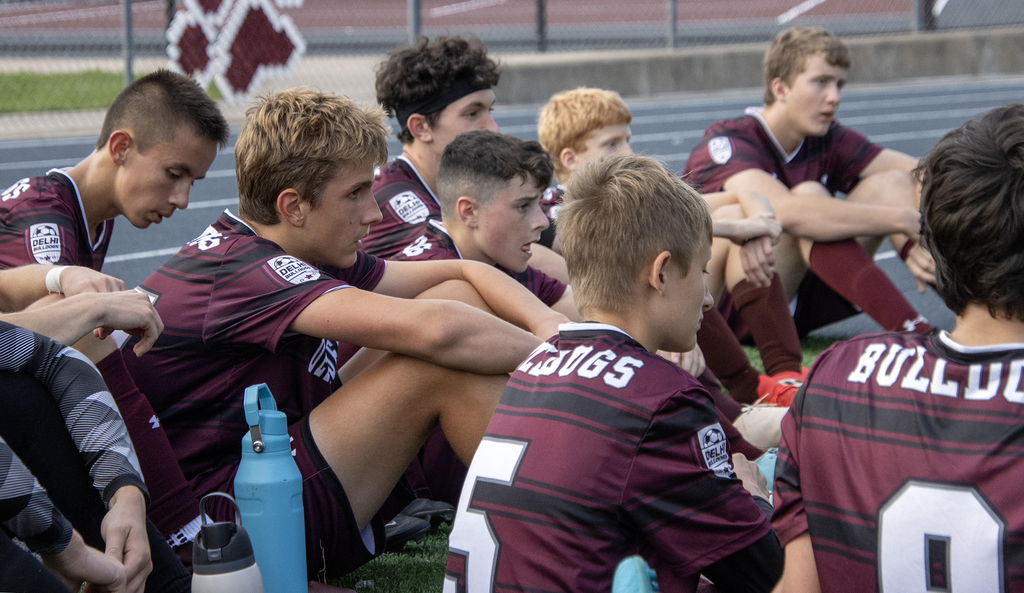 close up of 8 players as they listen to their coach