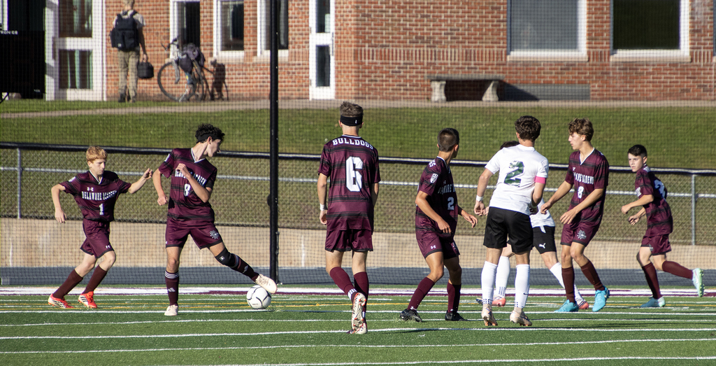 seven boys on the field in a soccer action shot.