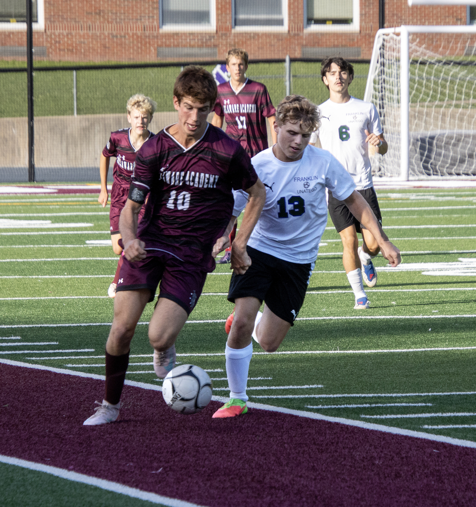 Benny Schnabel drives with the soccer ball, closely defended by another player