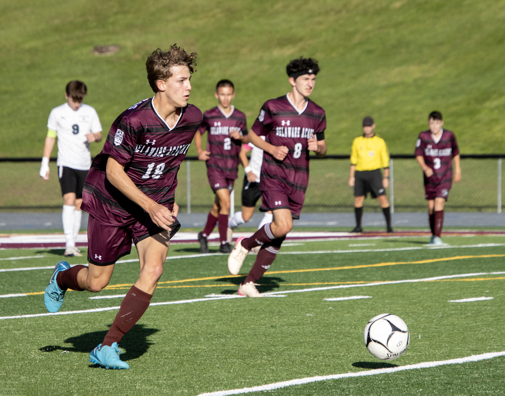 4 Bulldog players running, one in control of the ball.