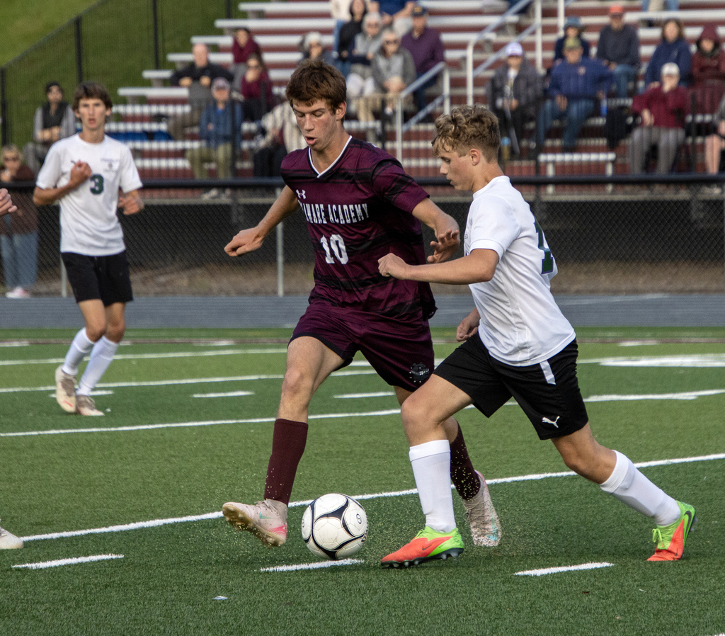 two soccer players fight for the ball