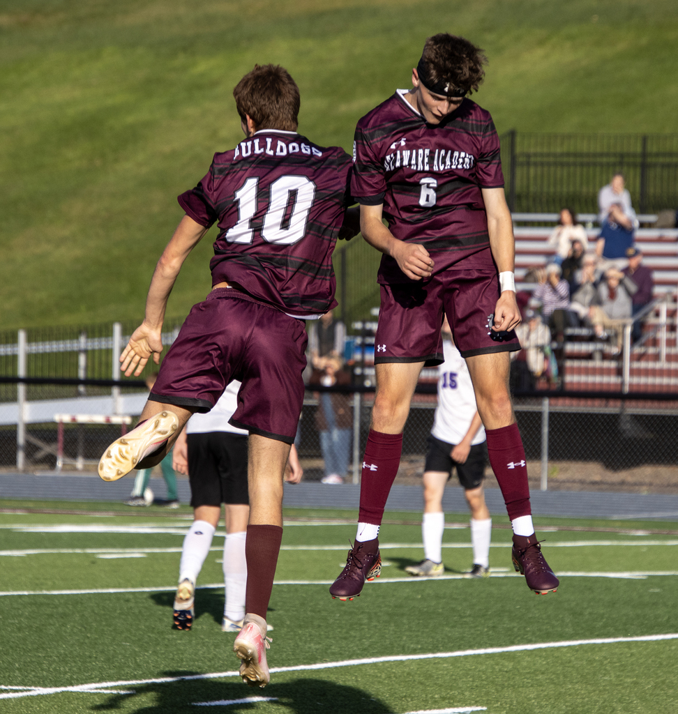 2 soccer players celebrate after one scores a goal