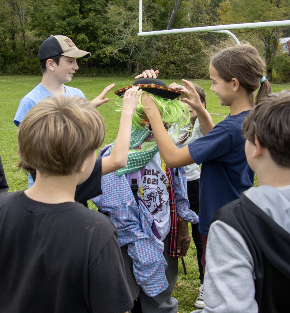 students are dressing another student in funny costume items