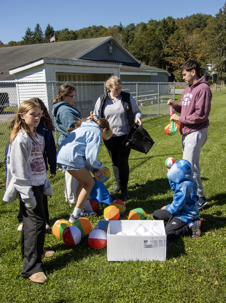 Mrs. Button, Mr. Layman and several students getting inflatable balls ready for an activity