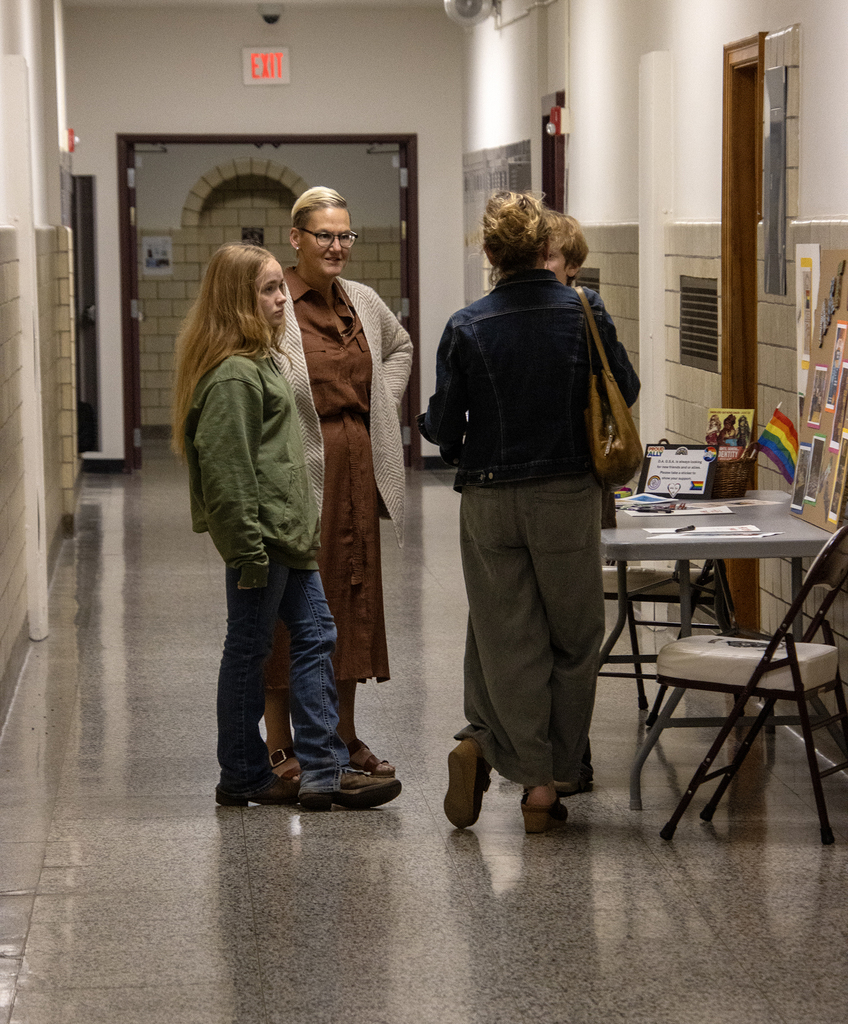 teacher talking to a student and family in the hallway
