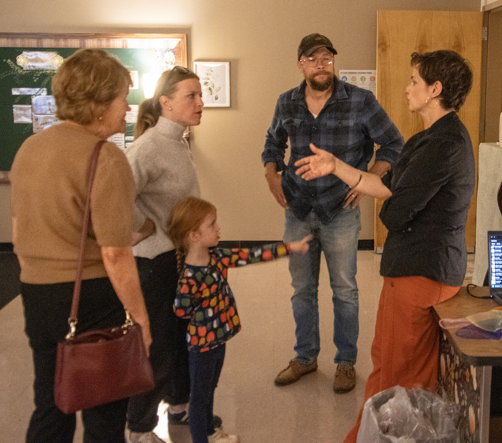miusic teacher speaks to a family; child points to her