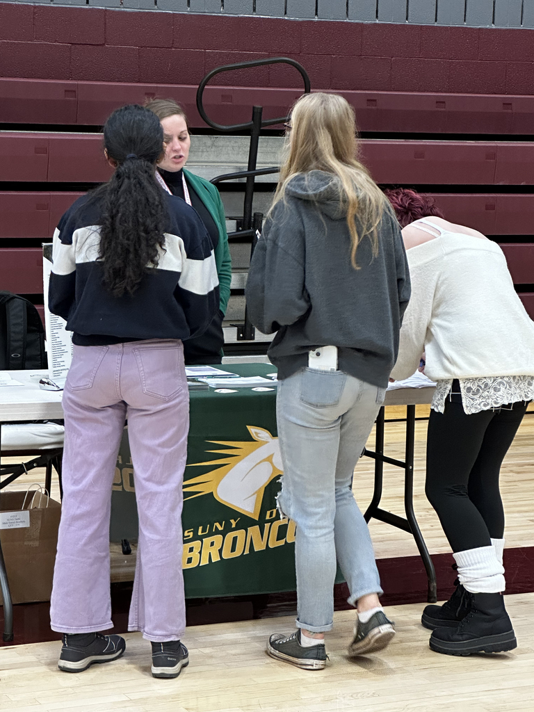 3 students talk to an adult at the career fair
