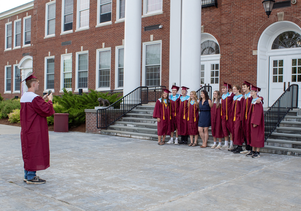 seniors in cap and gown posing for pictures