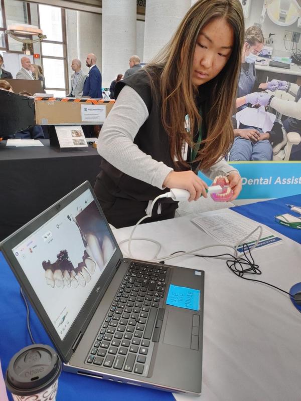 Dental Assisting student demonstrating equipment