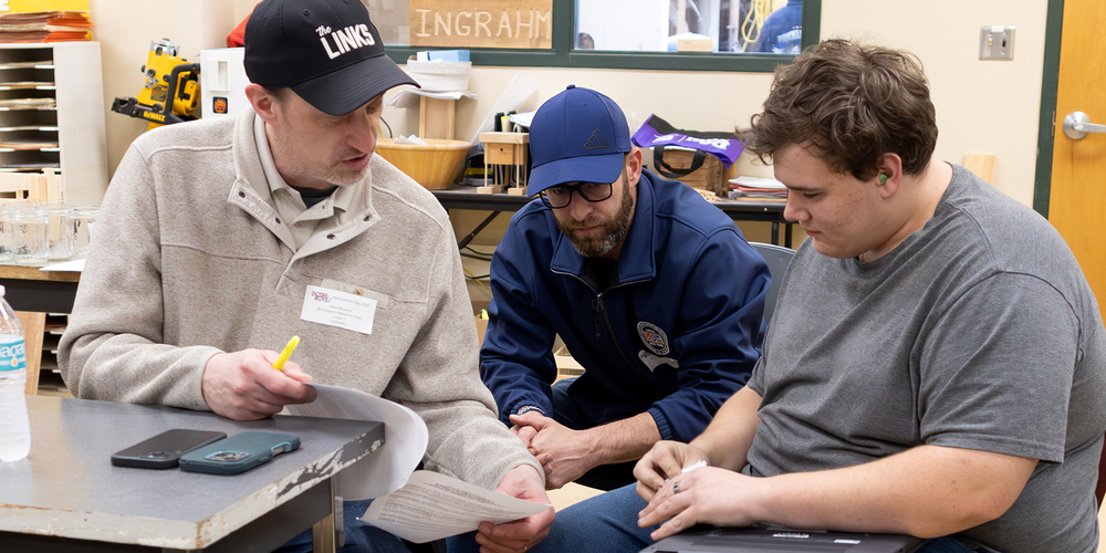 two recruiters speak with a student