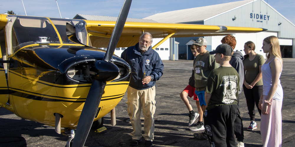 John Garzione goes over safety on an airplane for visiting students