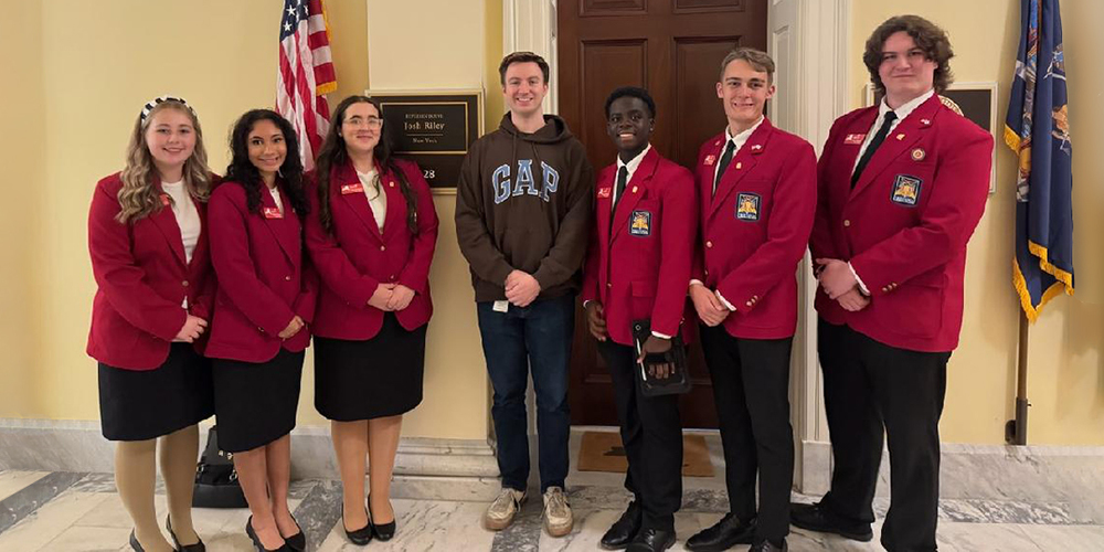 6 SkillsUSA state officers with a representative of Josh Riley outside his office