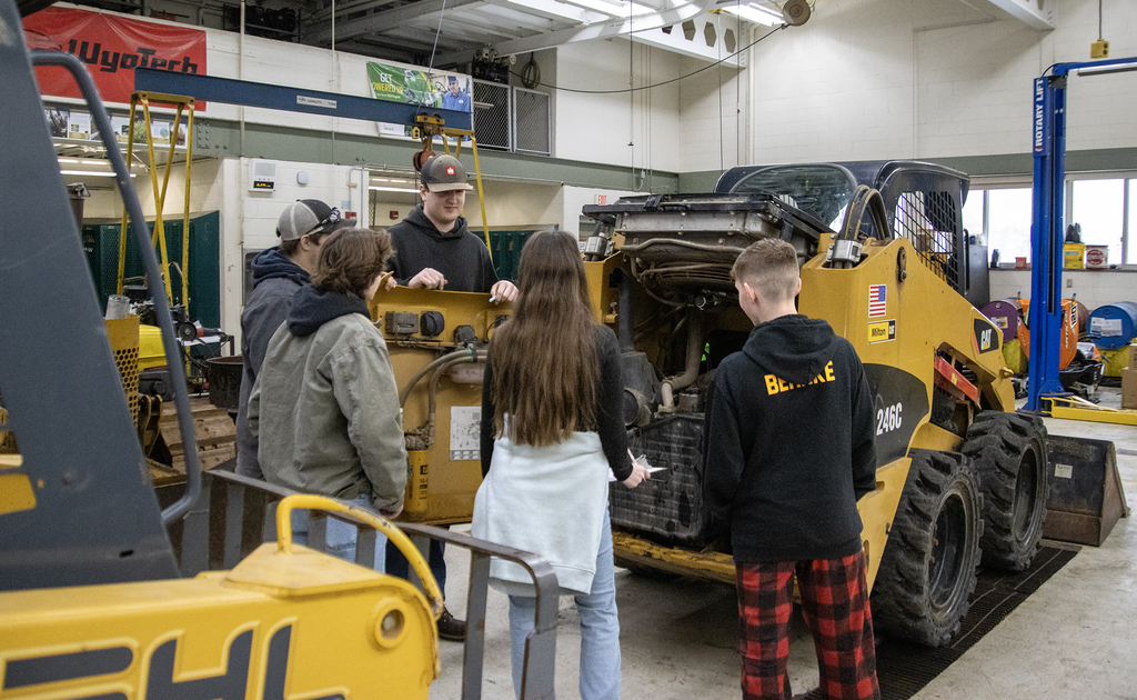 student quizzes 4 visiting students on skid steer parts