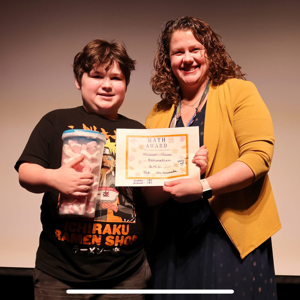 student and teacher with container of marshmallows and math award