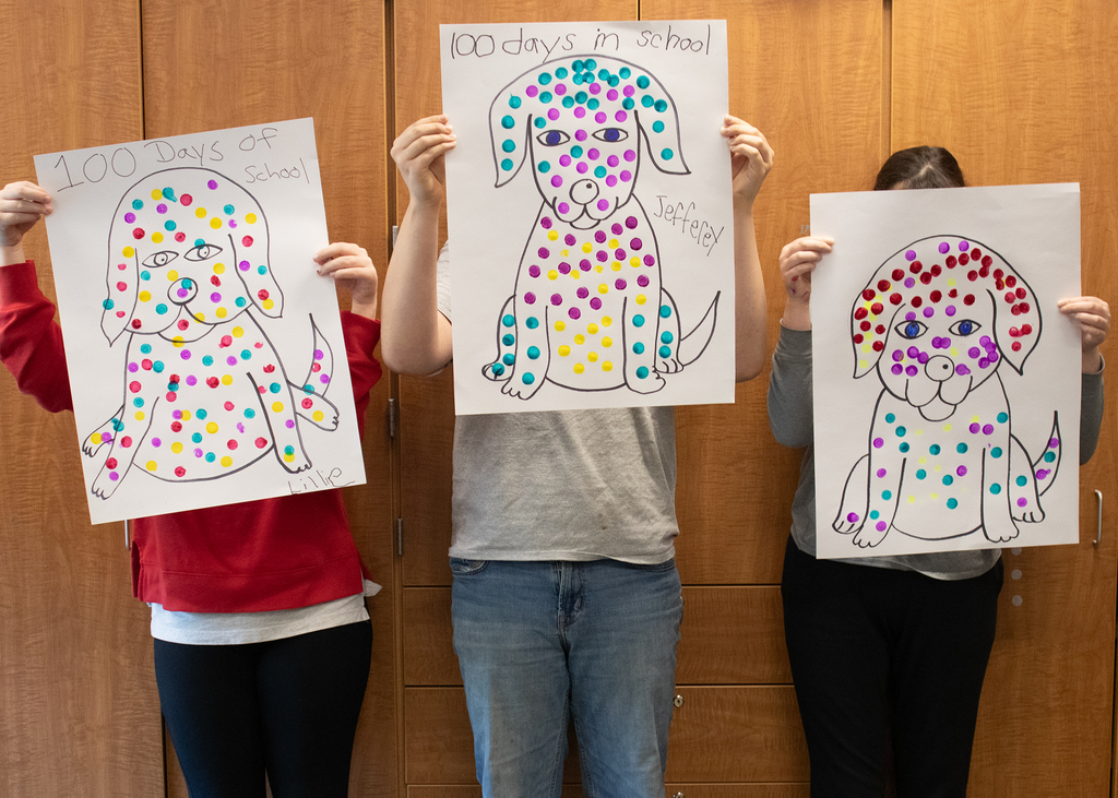 3 studewnts hold 100 day celebration drawings