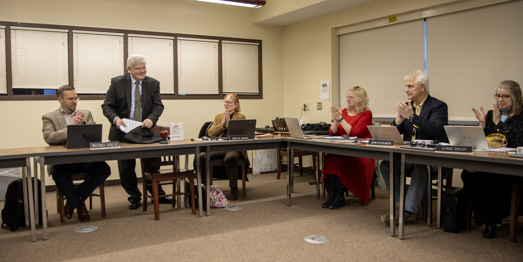Mr. Crumb puts away his notes as the board applauds