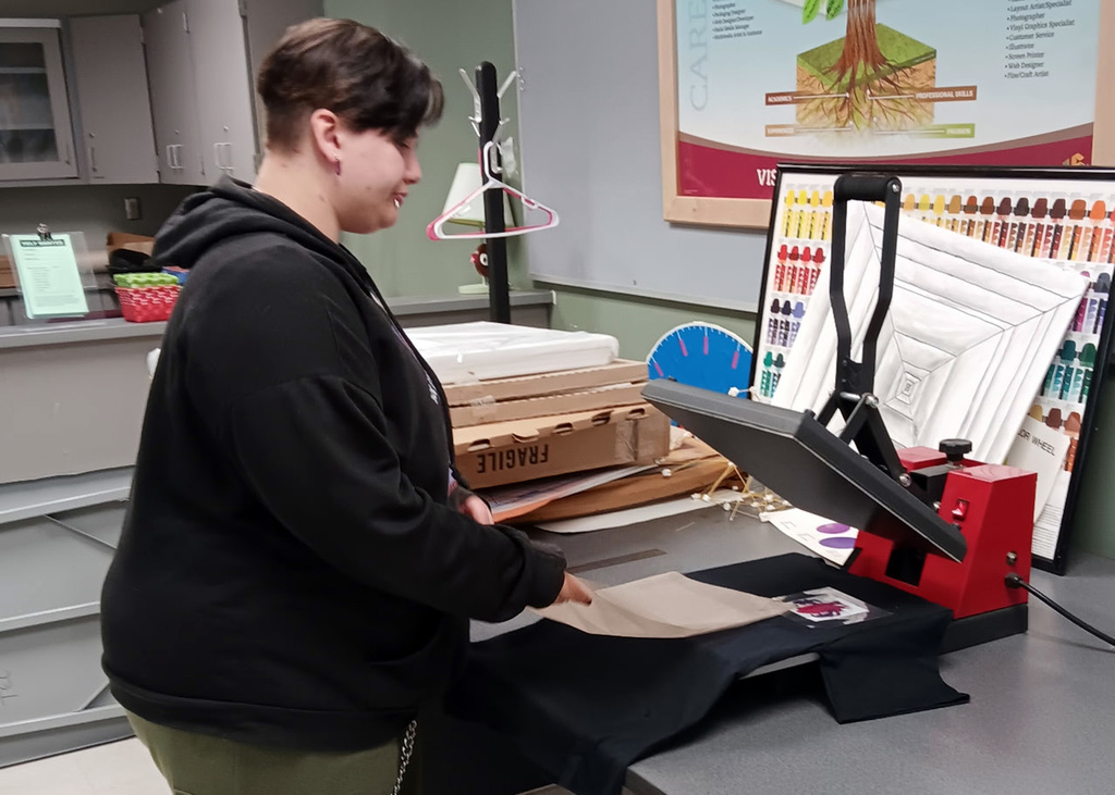 student works with t-shirt press