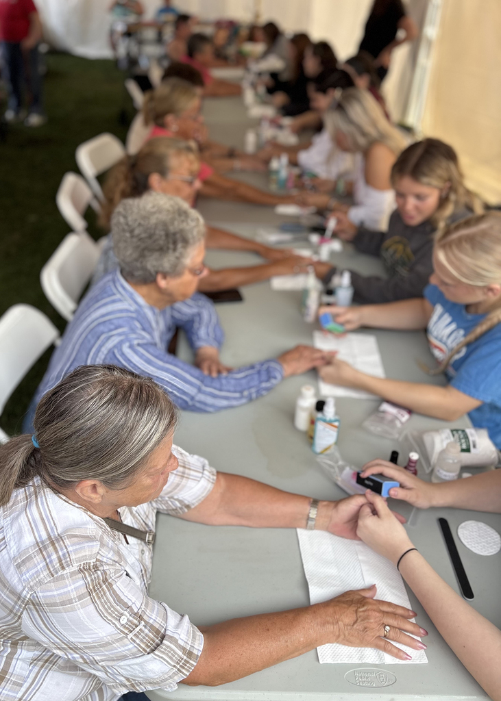 students at table fpainting seniors' nails