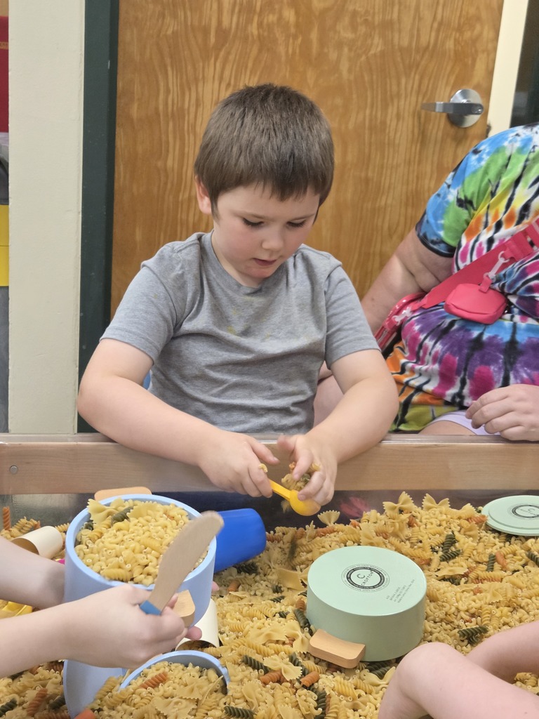 student playing in macaroni box