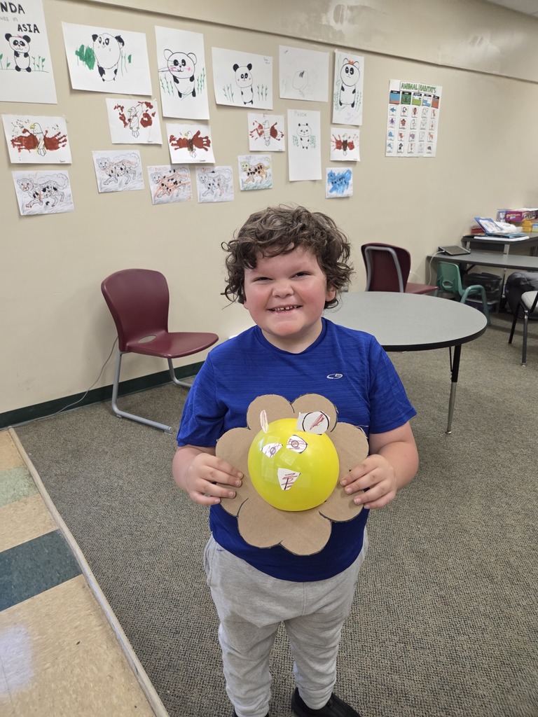 student smiles holding ballon art