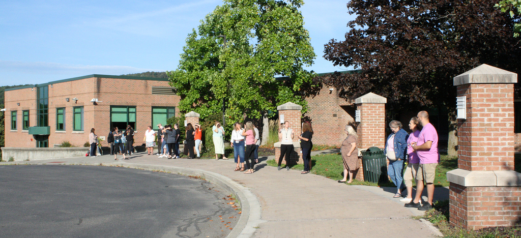 staff wait outside building