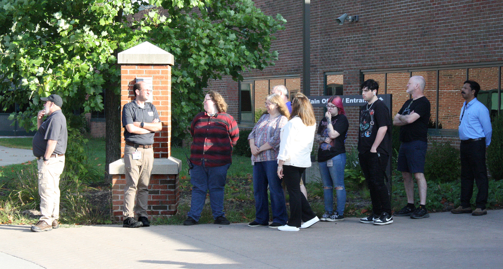 staff wait outside building