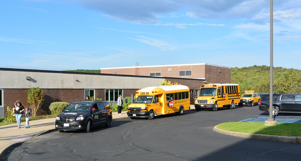 school buses lined up in front of building