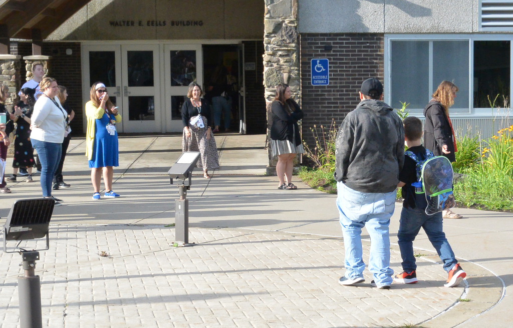 staff applaud as adult and student approach school