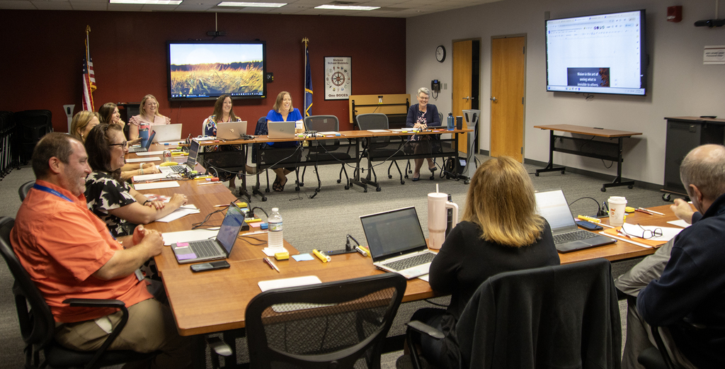 steering committee members around a table, laughing