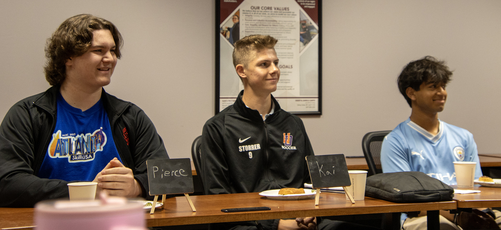3 students smiling at table