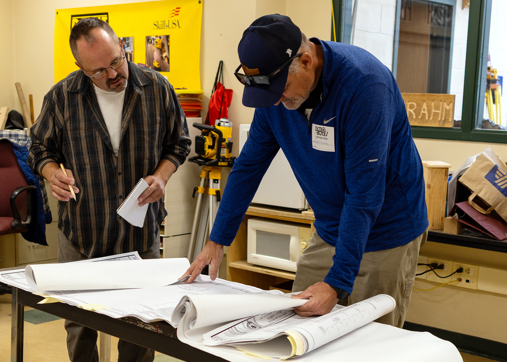 teacher and speaker look at blueprints