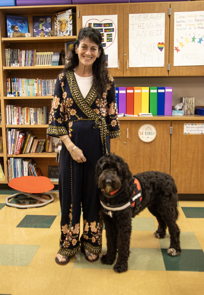teacher poses with therapy dog